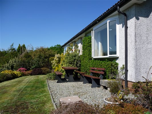 holiday cottage garden seating area with bench and picnic table